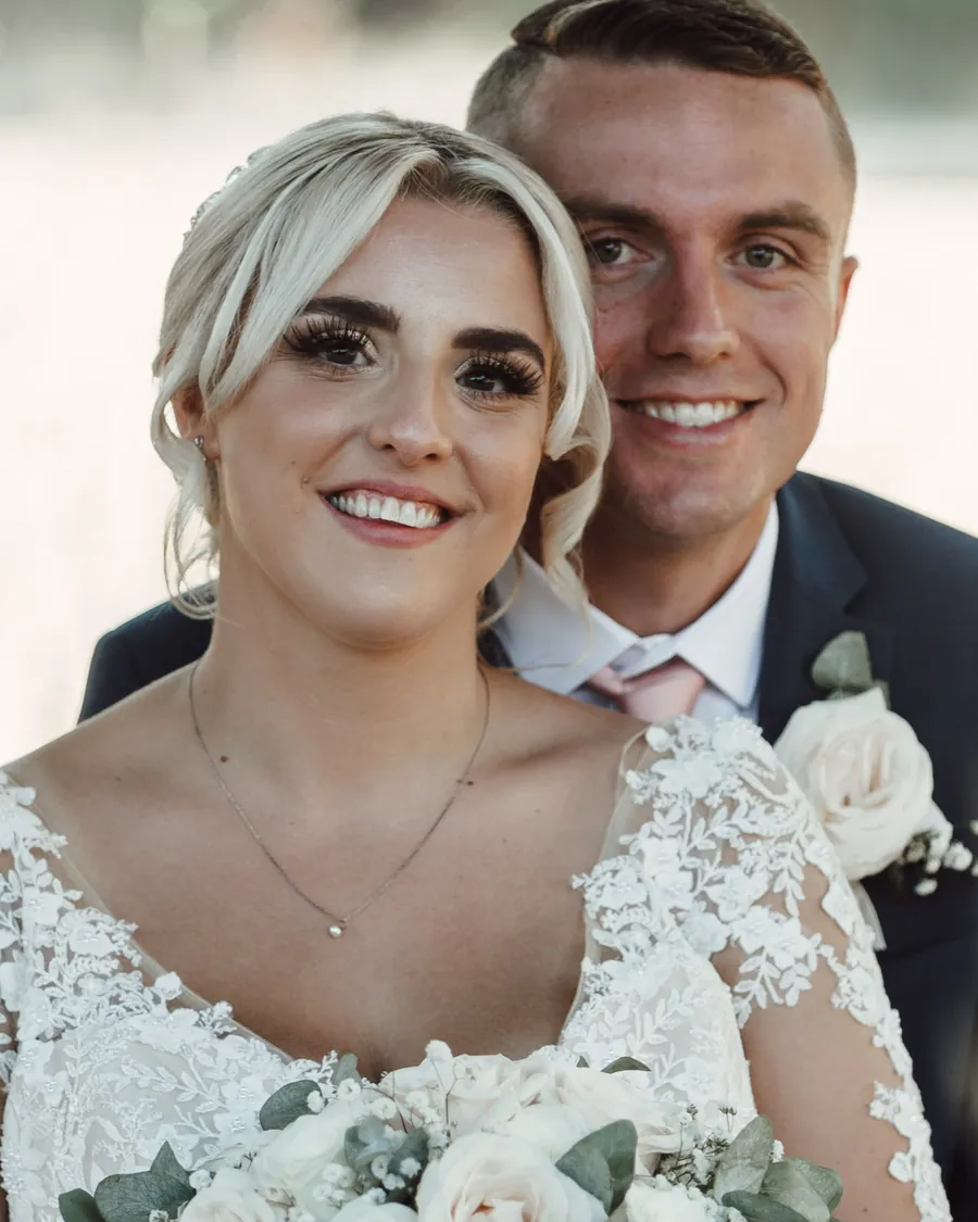 A bride and groom smiling together, cheek to cheek