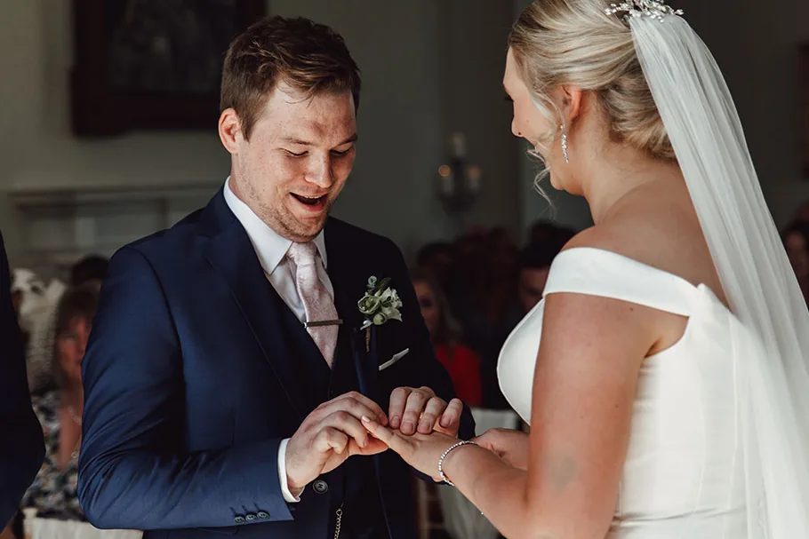 Groom placing the ring on his bride's finger during the ceremony