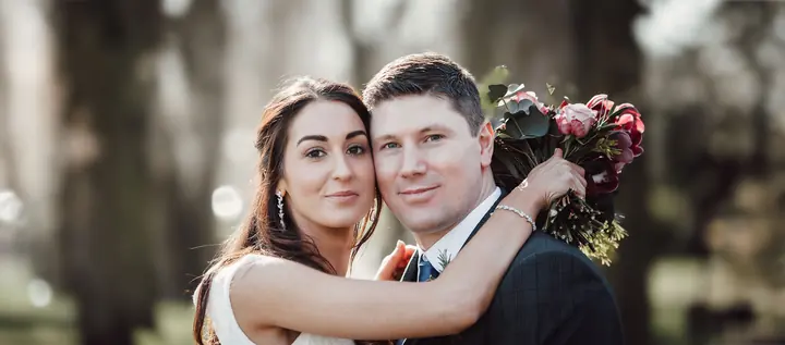 A couple cheek to cheek, smiling at the camera