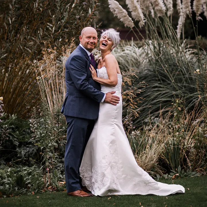 A couple standing among tall ornamental grasses