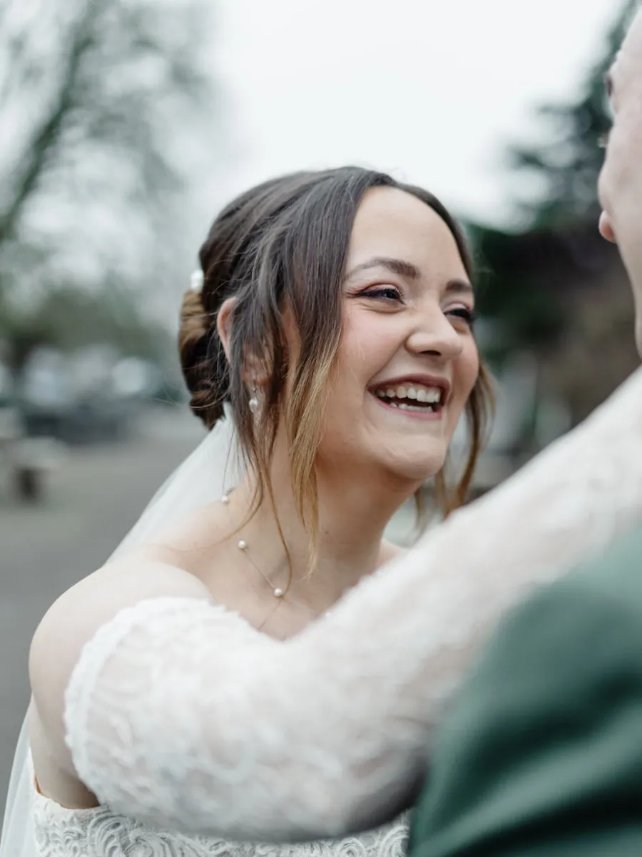 A bride laughing as she embraces her groom