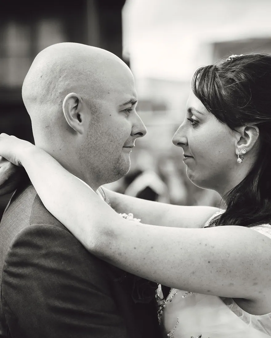 Black and white photograph of a couple embracing, foreheads almost touching