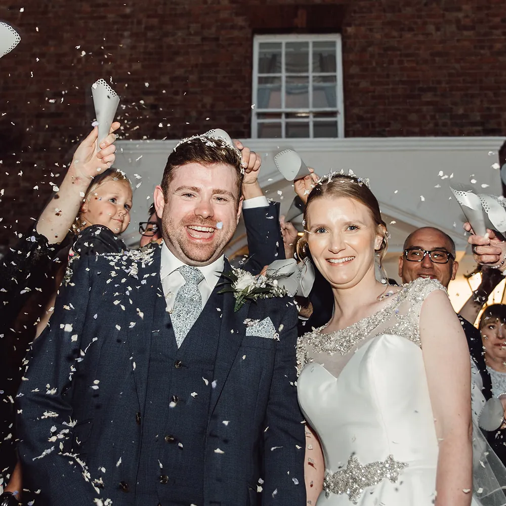 Guests throwing confetti over the newlyweds