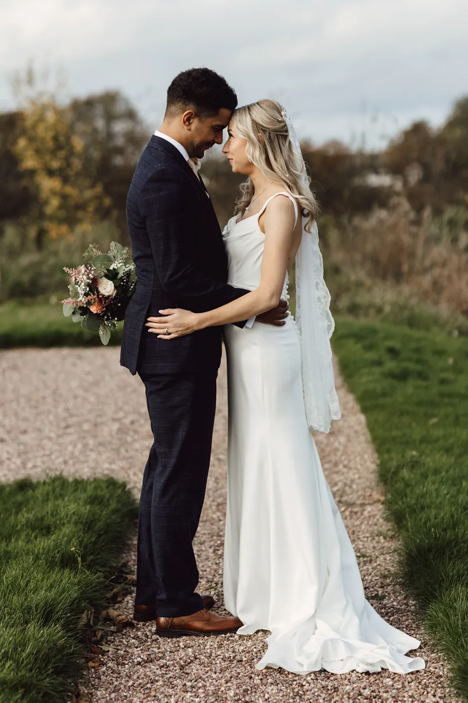 A couple standing close together on a garden path