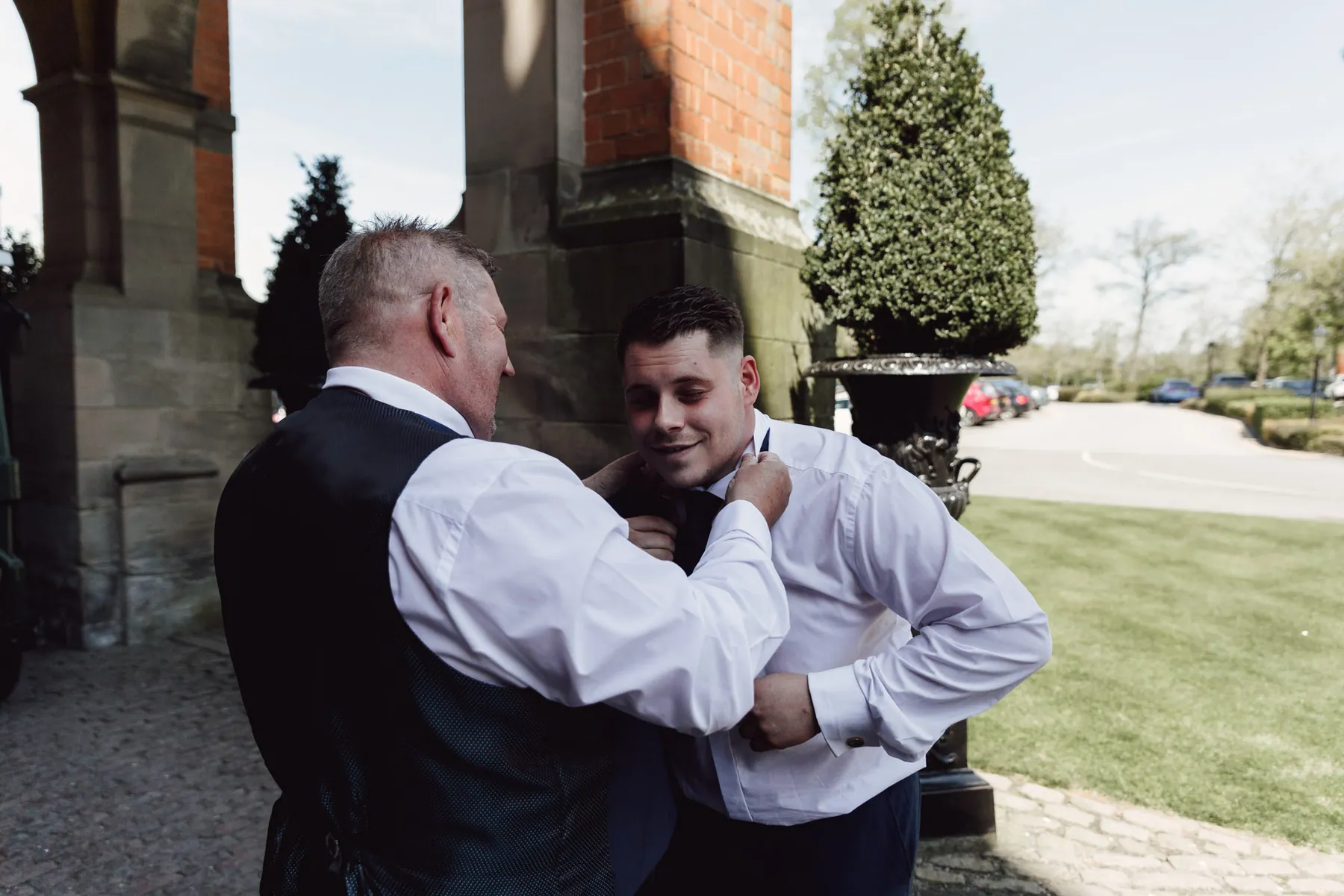 A groom having his collar straightened before the ceremony